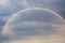 Panorama cloudscape view of natural colorful rainbow before dramatic sky