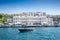 Panorama of the coast of Bosporus in Istanbul, turkey, with a small yacht posing in front of a luxury ottoman palace on the sea,