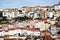 Panorama of Coimbra town, former medieval capital of Portugal. View of colorful houses and roof tops over blue sky