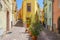 Panorama of the colorful town of Bosa along a river and hills in sunlight in spring