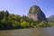 Panorama of the Columbia River with green river water with a light breeze, the wooded banks, the trees in the water, a huge and p