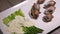 Panorama of cooked sea escargot snails with side dish of boiled green asparagus