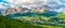 Panorama of Cortina d`Ampezzo with green meadows and alpine peaks on the background. Dolomites, Italy.
