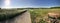 Panorama of country field with a speed bike on a country road