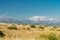 Panorama. Daytime landscape with a mountain range and a field with dry tall grass.