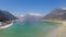 Panorama of deep blue lake at snowy mountains bottom, mirror-like water surface