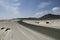 panorama with dirt road in Oman desert and bushes near horizon