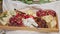 Panorama down on large wooden tray with fruits and sliced cheese