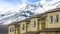 Panorama Exterior of houses with snow covered mountain and bright blue sky background