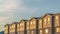 Panorama Exterior of townhouses with wood and brick wall sections and sliding windows