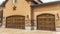 Panorama Facade of beautiful house with two brown wooden garage doors against cloudy sky