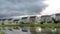 Panorama Family homes and bright cloudy sky reflected on the shiny neighborhood pond