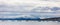 Panorama of floating sea ice in front of snowy mountains in the arctic