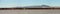 Panorama. Flock of pink flamingos at the Larnaca salt lake, Cyprus. Hills with windmills on background