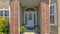 Panorama Flowers and white door with sidelights and transom window at the entrance a home