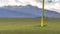 Panorama Focus on golf course yellow flagstick and hole in the middle of putting green