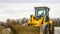 Panorama Focus on a yellow bulldozer with dirty bucket and wheels at a construction site