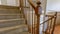 Panorama frame Carpeted staircase with brown handrail inside a house with shiny wooden floor