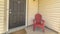 Panorama frame Entrance of a home with gray front door and red wooden chair on the porch