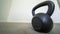 Panorama frame Focus on a heavy kettlebell inside a room with carpeted floor and white wall