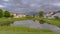 Panorama frame Grassy park with pond and pathways in the middle of lovely multi storey homes