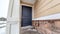 Panorama frame Home entrance with blue panel door and wall with stone bricks and wood siding