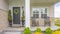 Panorama frame Home facade with stairs leading to porch with pillars and gray door with wreath