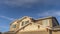 Panorama frame Home with front gable roof and dormers against vast blue sky with clouds