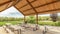 Panorama frame Pavilion with rows of white tables and benches under the brown wood ceiling