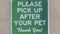 Panorama frame Sign that reads Please Pick Up After Your Pet against a concrete wall surface