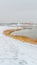 Panorama frame Snow covered trail with footprints along a silvery lake in winter