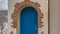 Panorama frame Stairs leading to the vibrant blue arched door at the entrance of a home