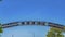 Panorama frame Welcome arch at the city of Ogden in Utah against lush treetops and blue sky