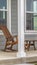 Panorama Front porch of a house with brown rocking chairs and rectangular white pillars