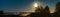 Panorama of full golden Moon close to pine trees, late summer night with clear skies and tiny white fog over water and coast line