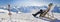 Panorama of a girl sunbathing in a deckchair near a snowy ski slope