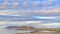 Panorama Gleaming lake with sandy shore and rugged mountain in the distance