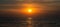 Panorama of golden sunrise or sunset over the sea, ocean. Flock of birds flying on the background of the sun.