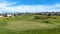 Panorama Golf course and homes under blue sky with clouds viewed on a sunny day