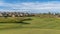 Panorama Golf course with lush green fairway and lovely houses under blue sky and clouds