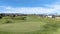 Panorama Golf course with view of lovely homes and mountain under blue sky with clouds
