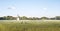 Panorama of a grainfield and a windmill in the morning sun with fog. Bayreuth, Germany.