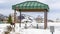 Panorama Green cabana with barbecue grill and picnic table at a snow covered park