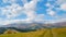 Panorama of green hills, trees and amazing clouds in Carpathian mountains in the autumn. Mountains landscape background