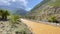 Panorama of a green mountain valley. Amazing mountain landscape with a dirty stormy river. Summer landscape