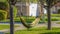 Panorama Hammock tied to the branches of trees with white flowers in spring
