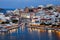 A panorama of the harbor city of Agios Nikolaos. View of the night sea, interesting landscapes, colorful houses, a coast view from