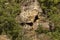 Panorama with high vertical limestone rocks and niches, ruins of former rock monastery