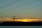 Panorama of high voltage power lines near water at sunset