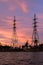 Panorama of high voltage power lines near water at sunset